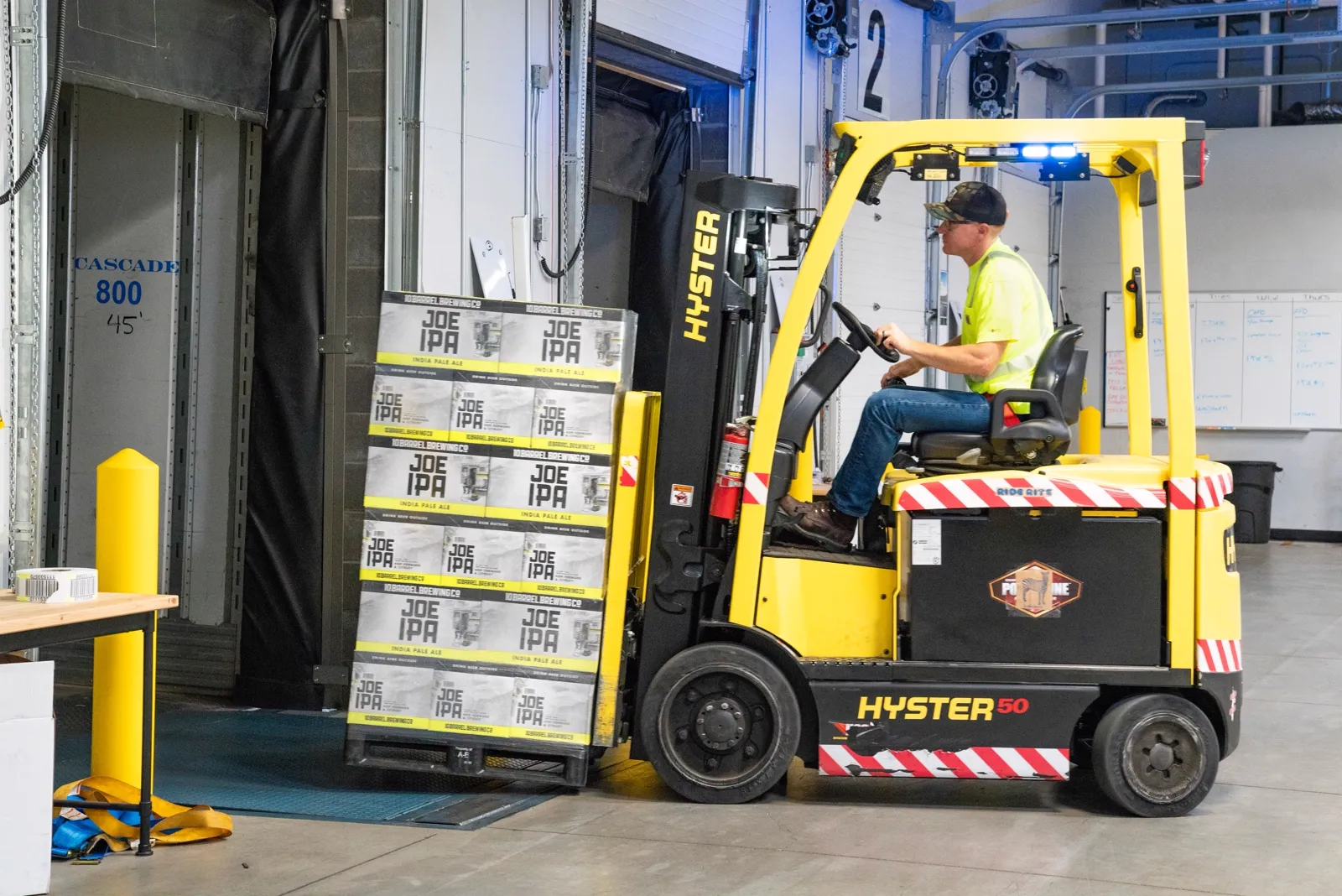Used Hyster 50 forklift loading pallets at a warehouse dock, for sale in Hampton Roads